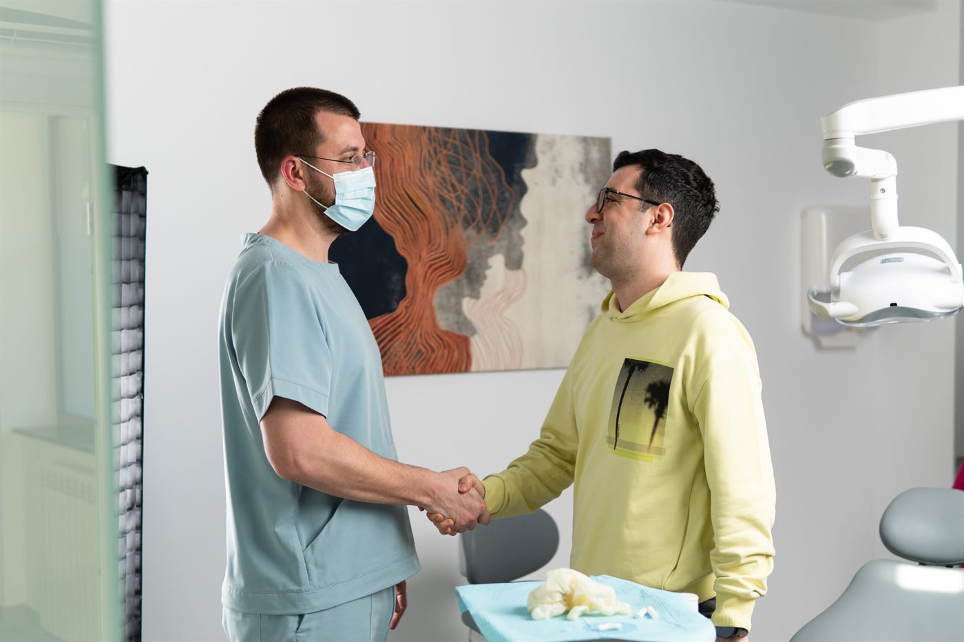 Medic și pacient dându-și mâna la finalul consultației